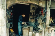 Χαλέπι (το 1999) Σιδεράς σφυρηλατεί πάνω από ένα αμόνι στο μικρό εργαστήρι, κοντά στην πύλη al-Hadid