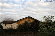 Μόλις και διακρίνεται πάνω από τον μαντρότοιχο η δίριχτη στέγη του Αγ.  Γεωργίου Εντιρνέκαπου (Νοεμ. 2008)