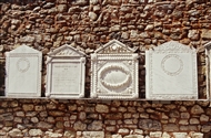 Τέσσερις από τις δεκάδες μαρμάρινες ταφόπλακες του 19ου αι. τις εντοιχισμένες στον μαντρότοιχο της Παναγίας της Καφφατιανής